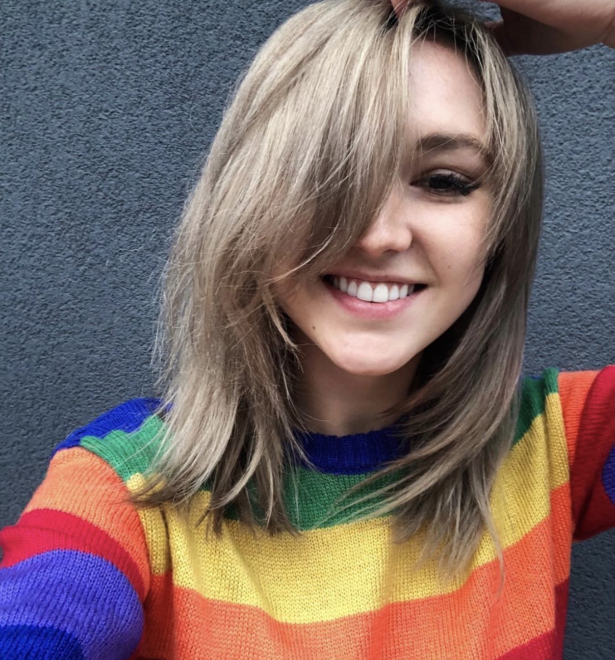 Maunder's founder, smiling in a rainbow-striped sweater against a grey wall